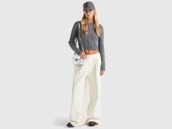 Cropped sweater with cable knit and perforations