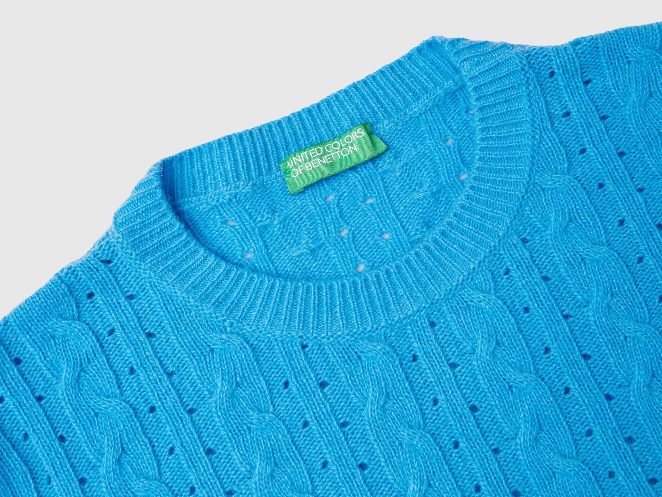 Cropped sweater with cable knit and perforations