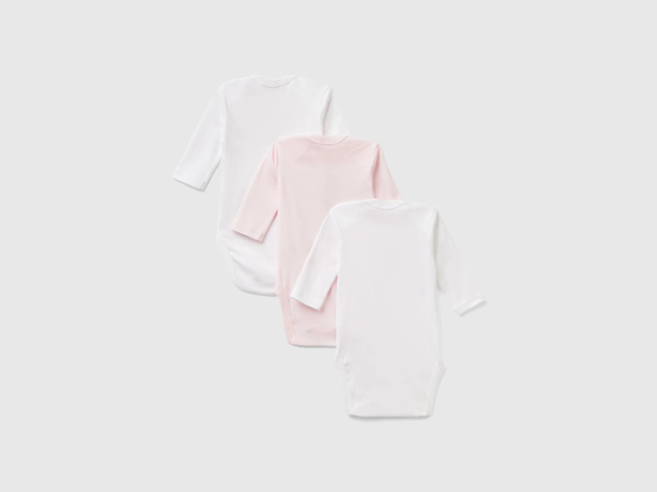 Three solid color bodysuits in organic cotton