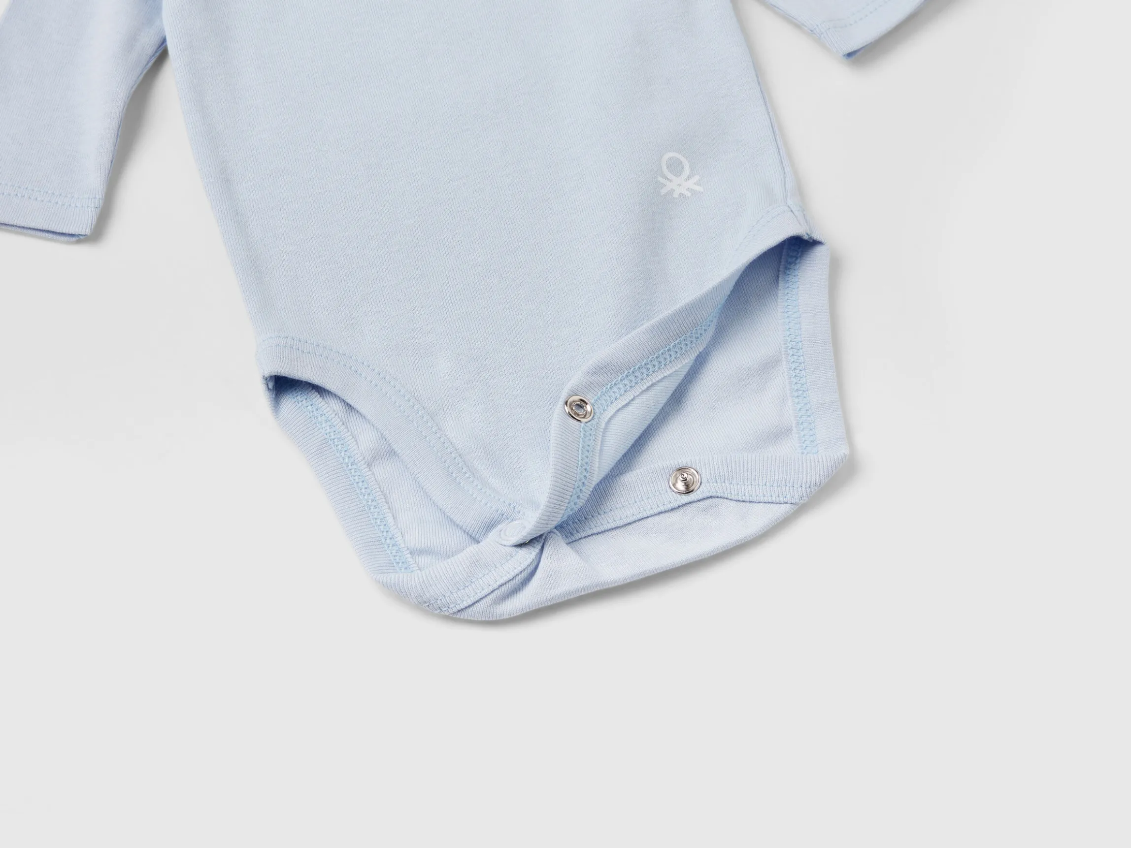 Three solid color bodysuits in organic cotton