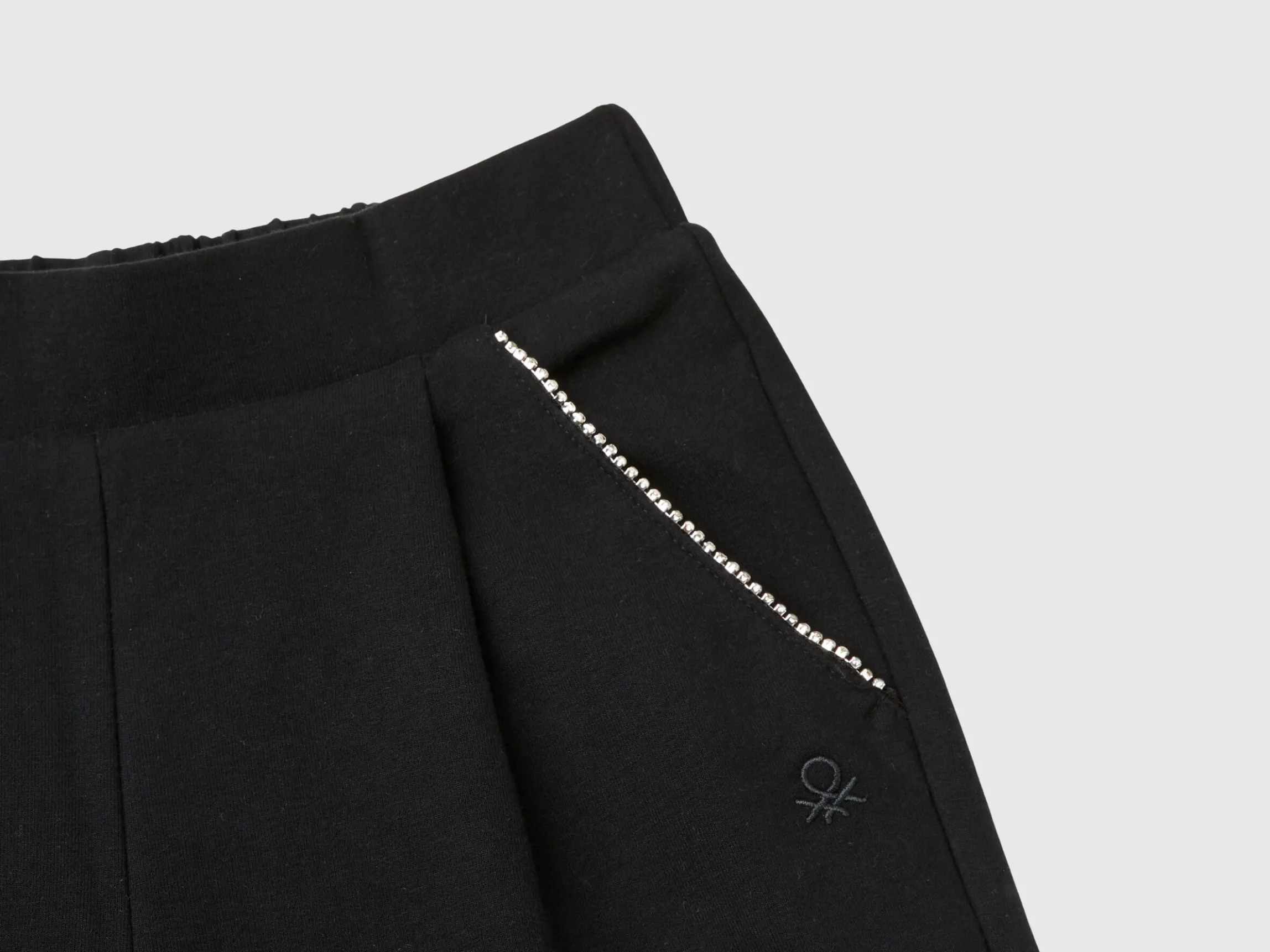Trousers with jewel-like applique